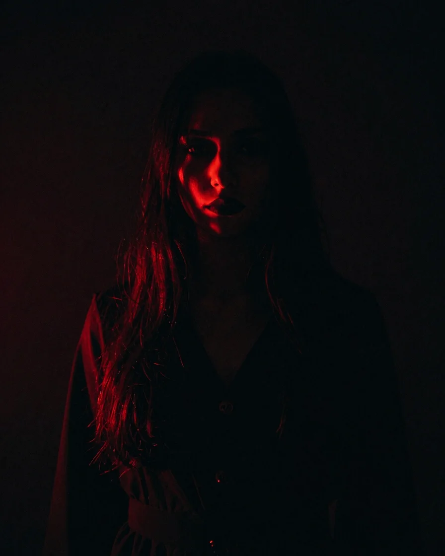 Moody atmospheric portrait of a shadowy figure illuminated by dra